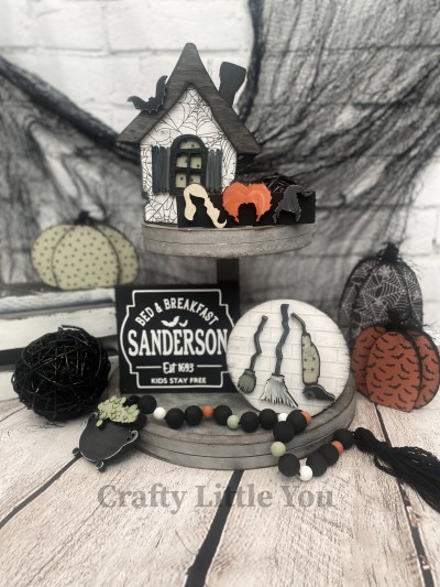 Unfinished kit measures apx. 6.75" tall on the house and includes: 
* 1 house with roof, window, and bat overlay
* 1 sign with 3 hair overlays
* 1 Sanderson Bed & Breakfast sign
* 1 circle sign
* 2 broom and 1 vacuum overlay
-- Tiered Tray Sold Separately --
