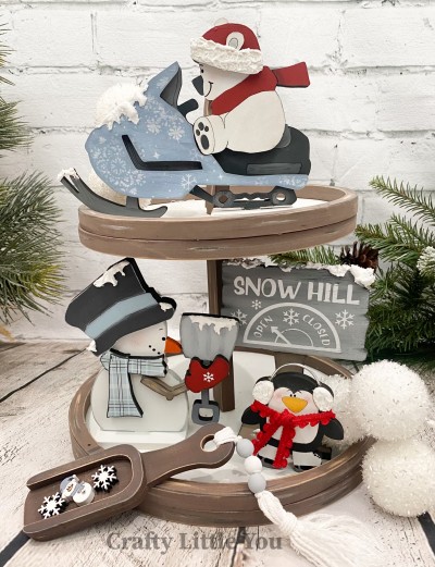 Unfinished kit measures apx. 6" tall and includes wooden MDF: 
* 1 polar bear on snow machine main piece with polar bear, hat brim, and hood overlay
* 1 snowman with shovel main piece with arm and mitten, hat, and scarf overlay
* 1 penguin on ice skates
* 1 Snow Hill sign
* 3 bases
* White vinyl

*Tiered Tray not included.