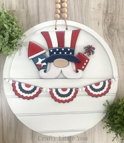 Unfinished kit measures apx. 7" tall and includes wooden MDF:
* 1 Uncle Sam main piece with attached fireworks
* 1 hat brim overlay
* 1 nose overlay
* 1 mustache overlay
* 1 triangle firework top overlay
* 1 firework burst overlay
* 2 star overlays for firework
* 3 engraved bunting banner pieces
* White vinyl stars
* 2 pieces Velcro