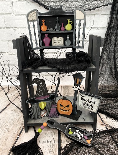 Unfinished kit measures apx. 7" tall on the potion cabinet and includes wooden MDF:
*1 potion cabinet
*1 potion cabinet top molding overlay
*2 potion cabinet doors (one with engraved spiderweb)
*2 cabinet shelves with attached potions, spell book, and rat
*1 potion cabinet base
*1 witch main piece
*1 witch face and hair overlay
*1 witch nose overlay
*1 broom
*1 jack-o-lantern
*1 lamp post with attached sign and engraved wording
*1 skull and crossbones overlay
*1 lamp post base