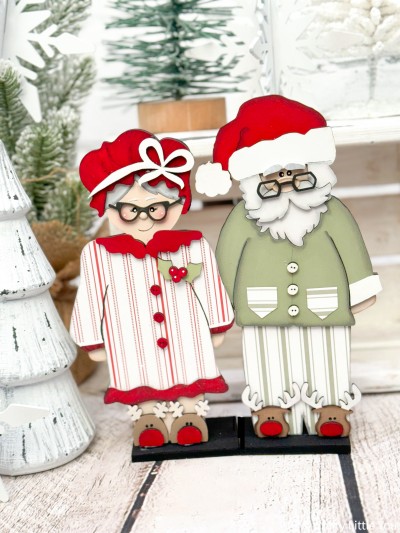 Unfinished kit measures apx. 9" and includes wooden MDF:
*1 Mrs. Santa main piece
*1 nightcap and bow overlay
*1 nightgown and collar overlay
*1 mistletoe and berry overlay
*1 Santa main piece
*1 hat pom-pom overlay
*1 hat brim overlay with attached beard
*1 mustache overlay
*2 eyebrows
(Eyes will be lasered into wood.)
*1 pajama shirt
*2 pocket overlays
*2 pair of glasses
*2 noses
*6 buttons
*4 reindeer slippers with nose overlays
*1 base
