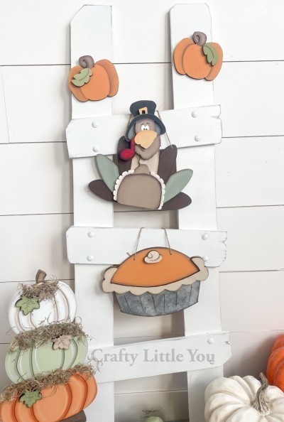 Unfinished kit measures apx. 8" tall on hanging pieces, and includes wooden MDF:
*1 turkey main body piece
*1 set of feathers
*1 turkey face overlay
*1 beak overlay
*1 pie main piece
*1 crust overlay
*1 whipped cream dollop overlay
*2 pumpkins
*2 leaves
*Black and white vinyl

*Top ladder kit pieces can be attached to ladder with Velcro or magnets.
Velcro dots can be purchased separately.
