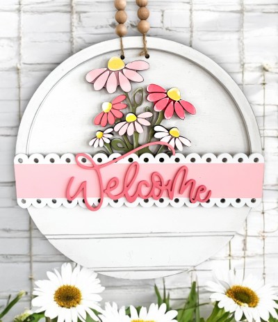 Unfinished kit measures apx. 7" tall on flowers and includes wooden MDF: *1 flower main piece *overlay petals for flowers *1 scalloped sign *1 “WELCOME” lasered word *2 velcro pieces